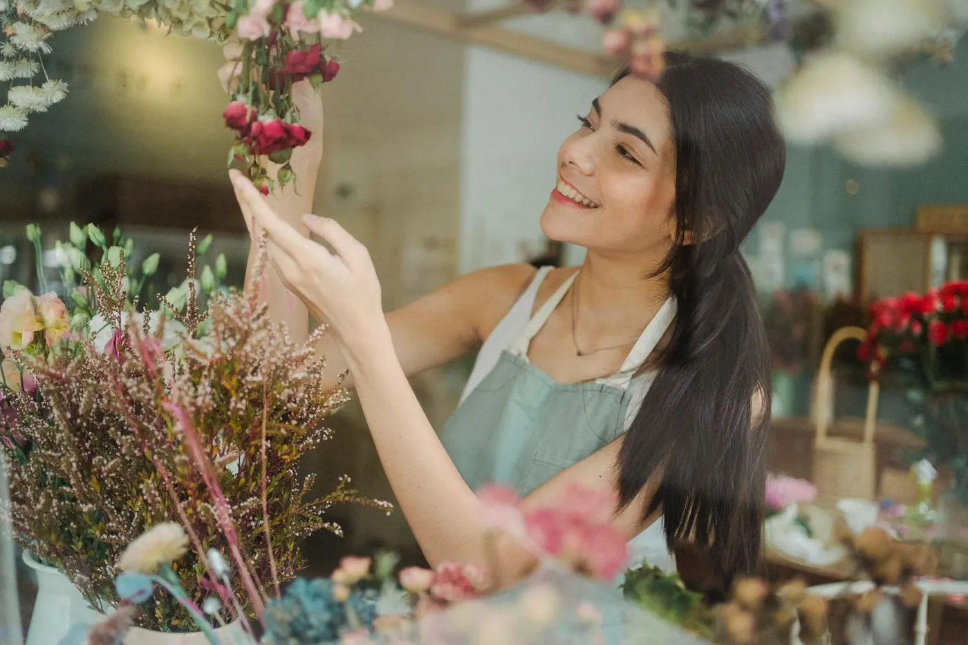 Une fleuriste souriante arrange des fleurs dans sa boutique